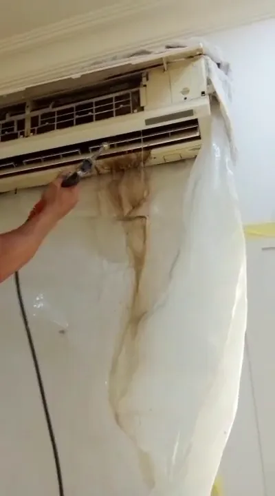 غسيل مكيف سبليت بالماء المضغوط ونزول الماء المتسخ على كيس بلاستيكي